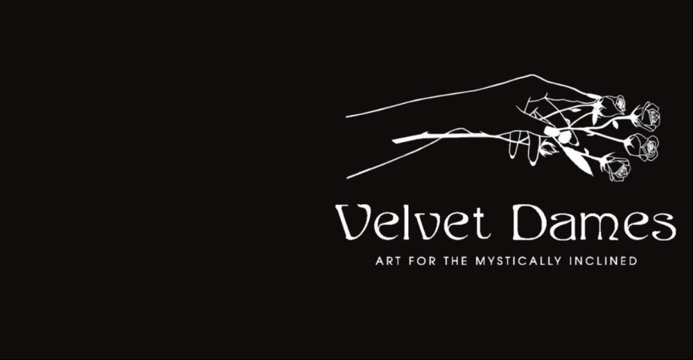 Black background with a white line-art illustration of my hand holding roses and the text 'Velvet Dames' and 'ART FOR THE MYSTICALLY INCLINED'.